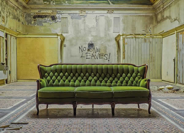 green victorian sofa in abandoned room